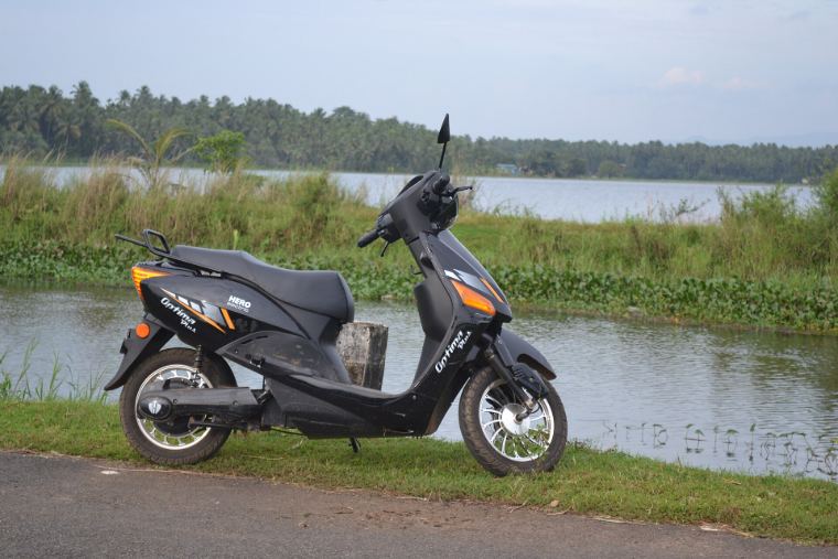An electric scooter parked by a lake